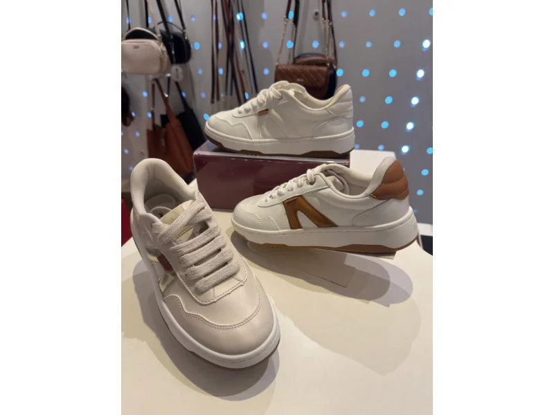 Três tênis na cor branca, com detalhes em marrom, disponível para venda na loja Ana Capri.