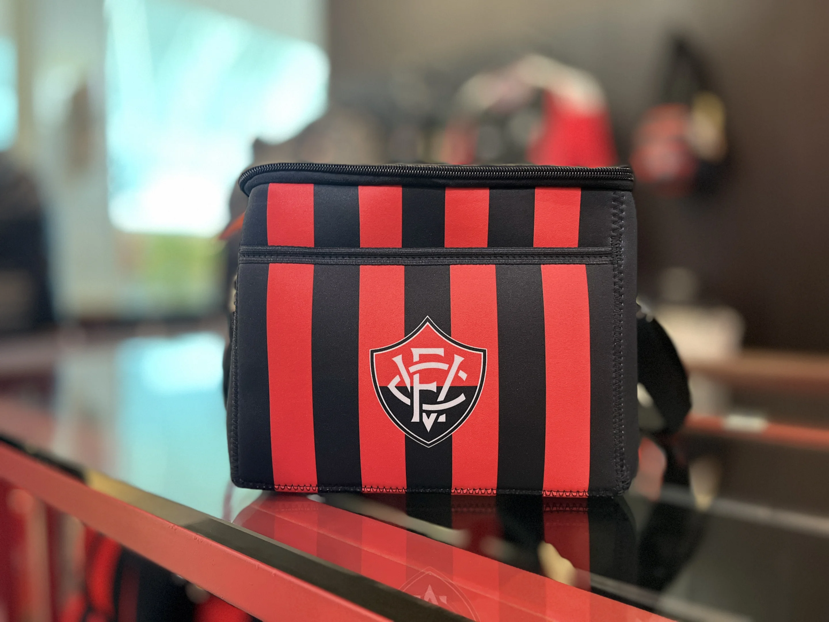 Bolsa térmica temática do time de futebol Vitória, listrada nas cores preto e vermelho.