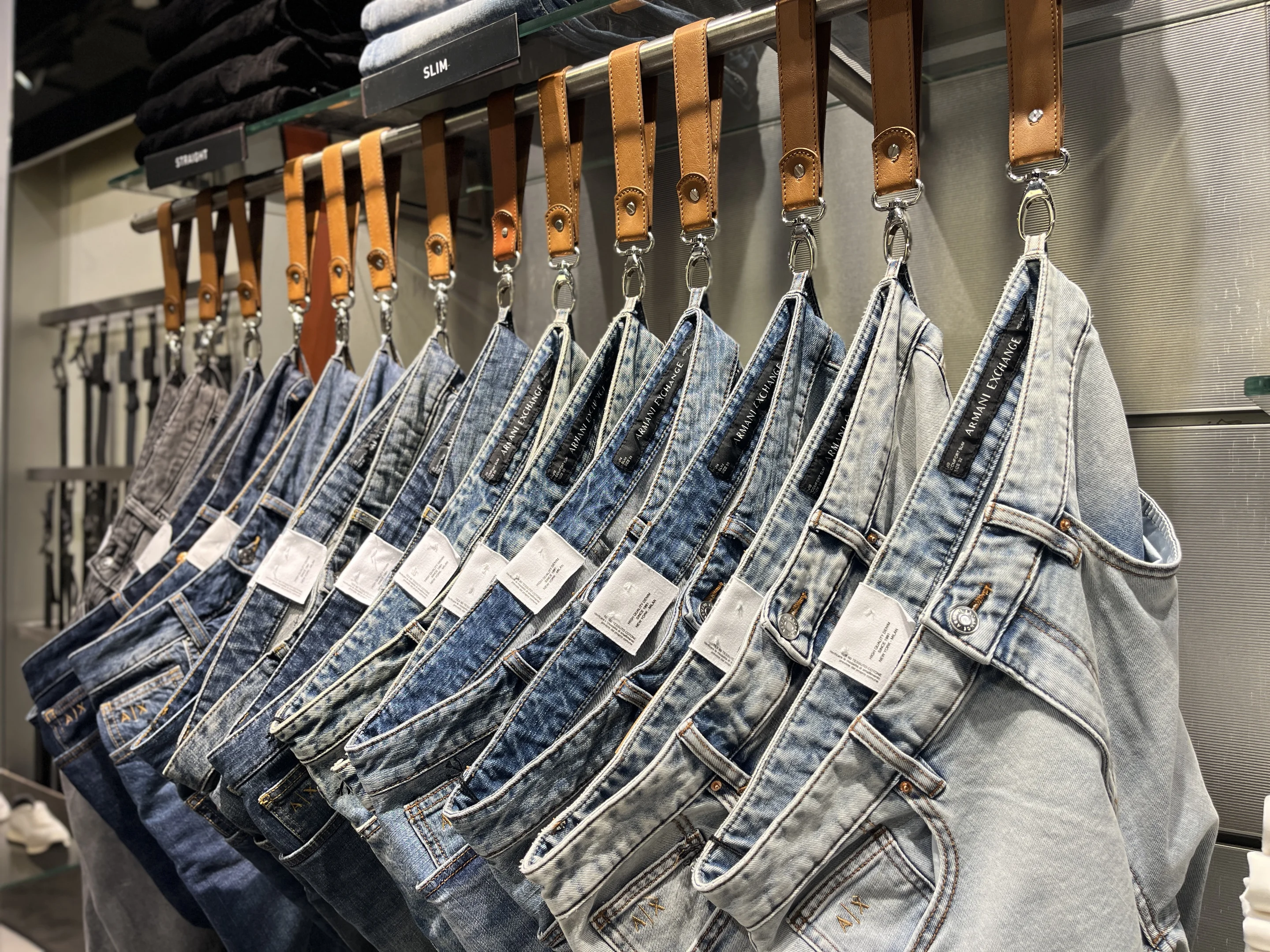 Arara com calças jeans em modelos diversos. Disponíveis na loja Armani Exchance.